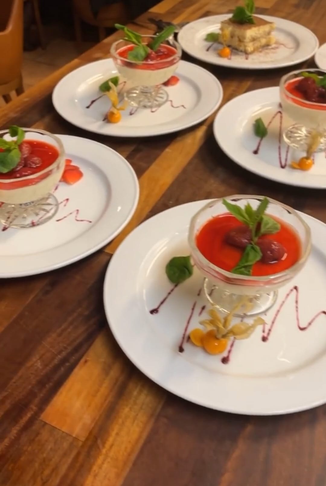 Pannacotta med bärkompott serverad på vita tallrikar